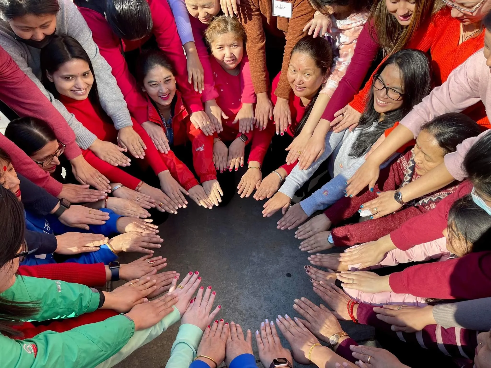 Adhikaar’s members putting their hands together in a circle.